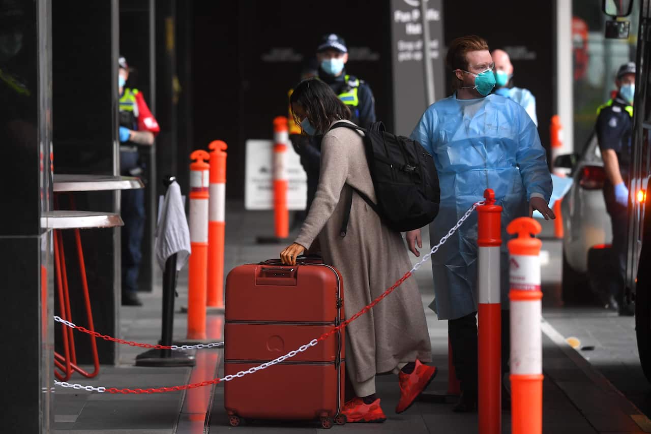 Passengers are seen disembarking a SkyBus and entering a hotel quarantine facility in Melbourne, Monday, December 7, 2020
