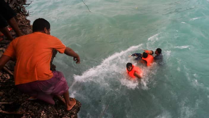Indonesian rescuers evacuate victims of a sinking ferry off the coast of Selayar island, in South Sulawesi, Indonesia.