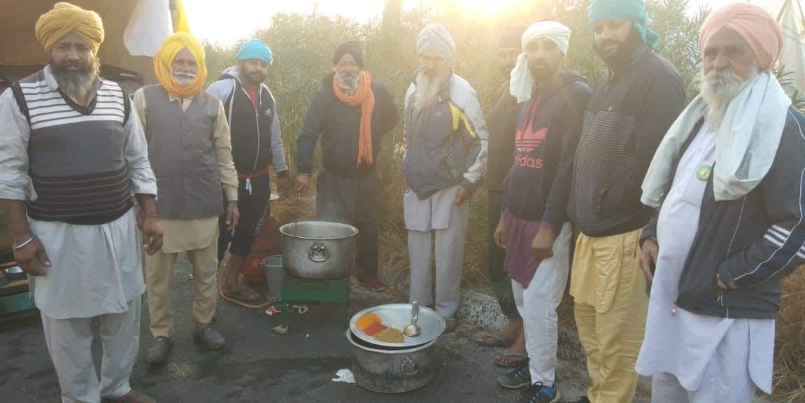 A group of farmers cooking food near the Delhi-Ambala highway.