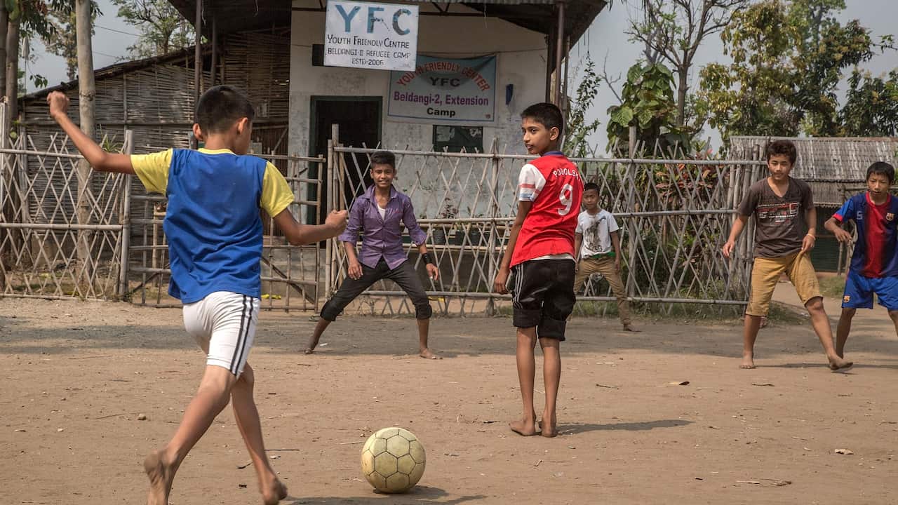 A group of young refugees play football on a field inside the Youth Friendly center funded by the UN High Commissioner for Refugees (UNHCR) in the Beldangi 2 refugee camp on March 14, 2015 in Beldangi, Nepal.