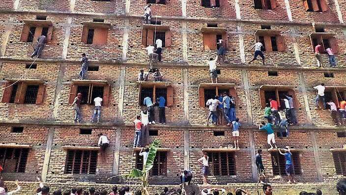 Indians climb the wall of a building to help students appearing in an examination in Hajipur, in the eastern Indian state of Bihar.