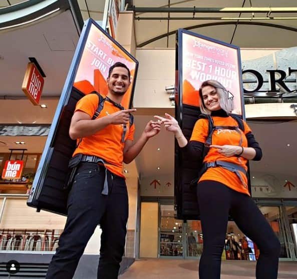 OnMove workers promoting businesses using billboards strapped to their backs.