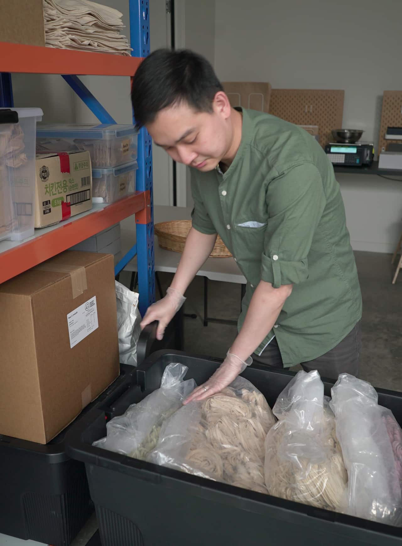 Brian Ooi sorting through bulk bags of dried noodles.