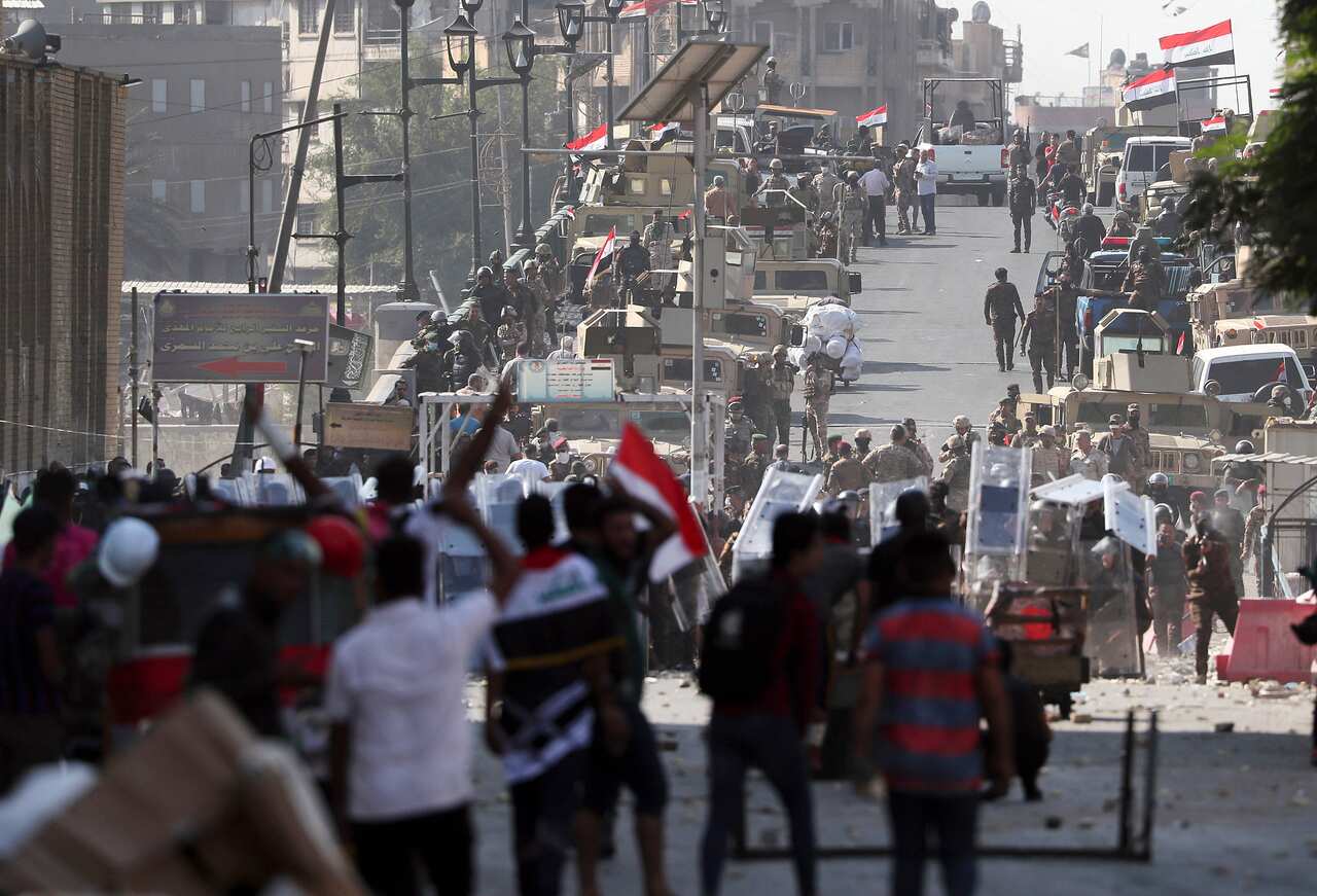 Iraqi Army soldiers try to prevent anti-government protesters from crossing the al- Shuhada (Martyrs) bridge in central Baghdad, Iraq
