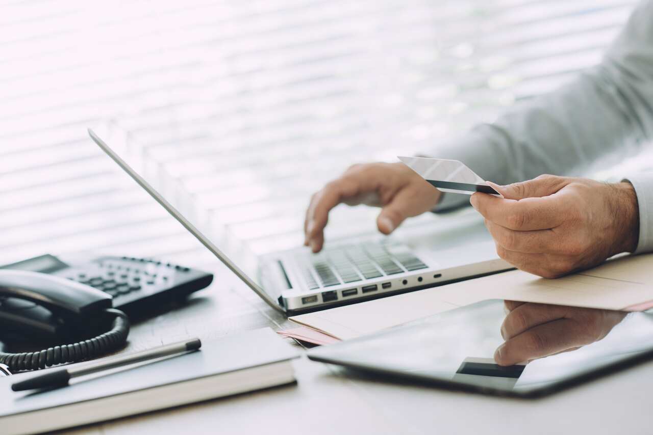 Businessman doing online banking, he is making e-payments with a credit card and his laptop, online business and finance concept