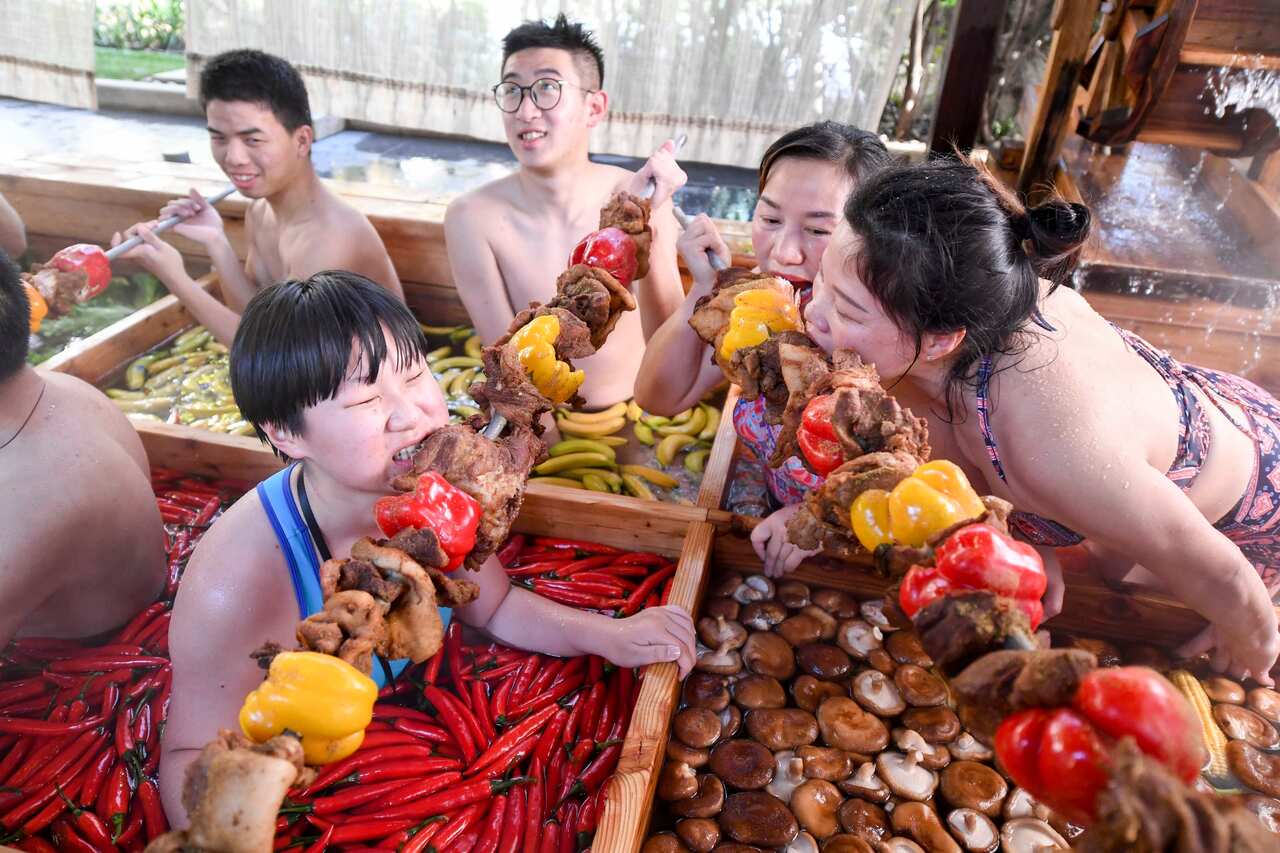 People born in the Year of the Pig eat kebabs in a hot pot shaped hot spring.