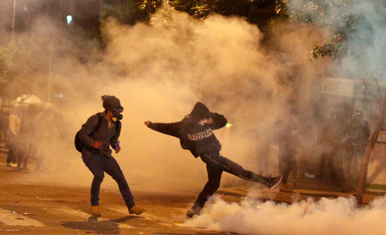 Protesters run away from tear gas fired by the police during an anti-government march against the reelection of President Morales.