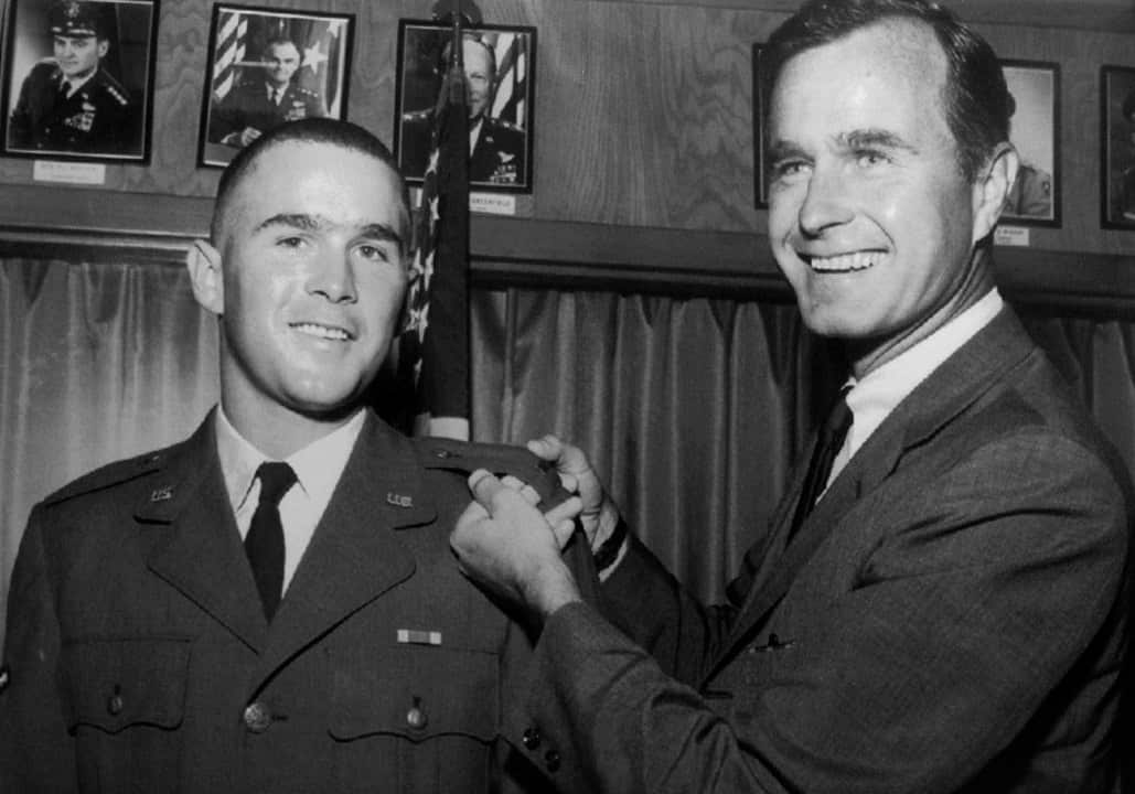 1968: George H.W. Bush, right, is about to pin a lieutenant bar on his son, George W. Bush.
