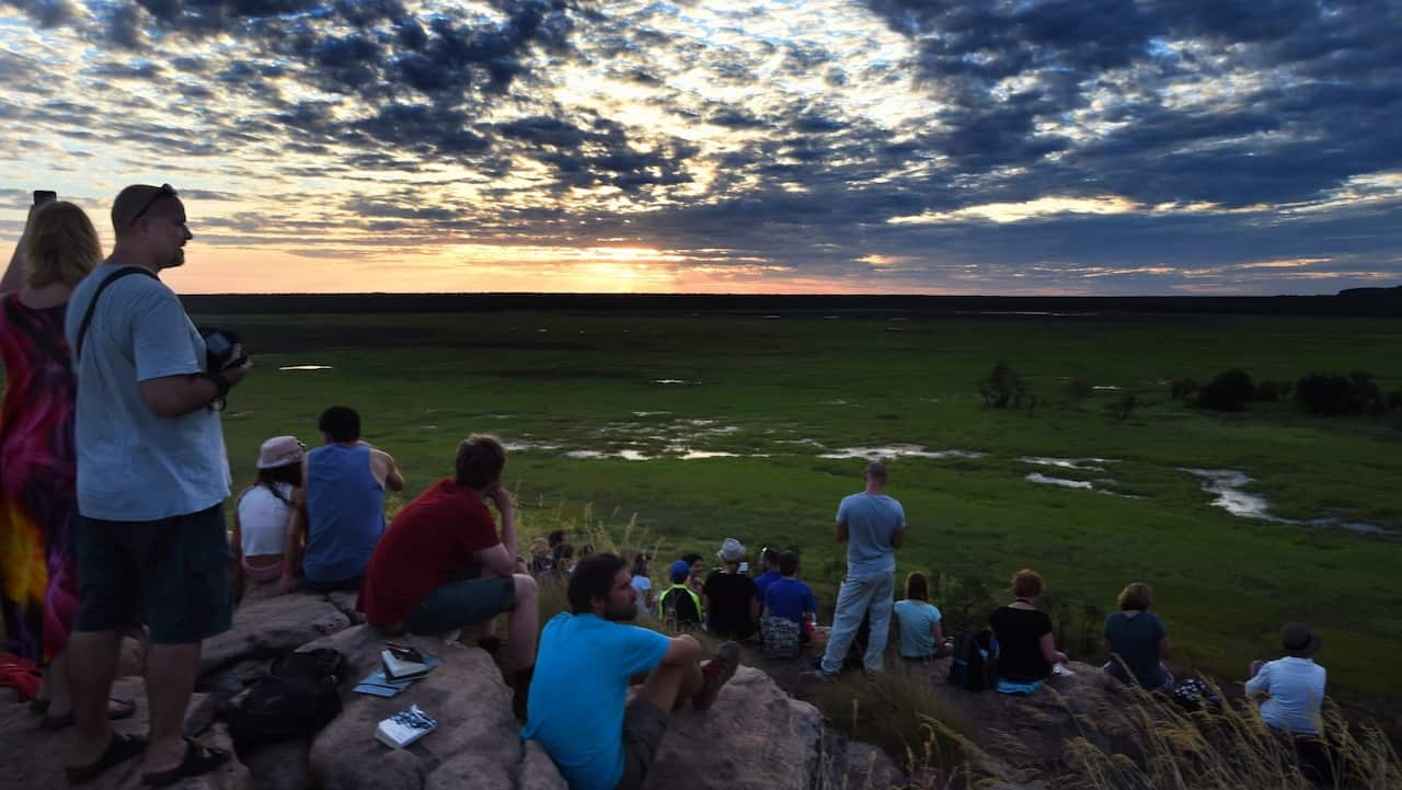 Tourists wait for sunset at Ubirr rock in the World Heritage listed Kakadu National Park, Darwin, Thursday, July 2, 2015. (AAP Image/Dean Lewins) NO ARCHIVING