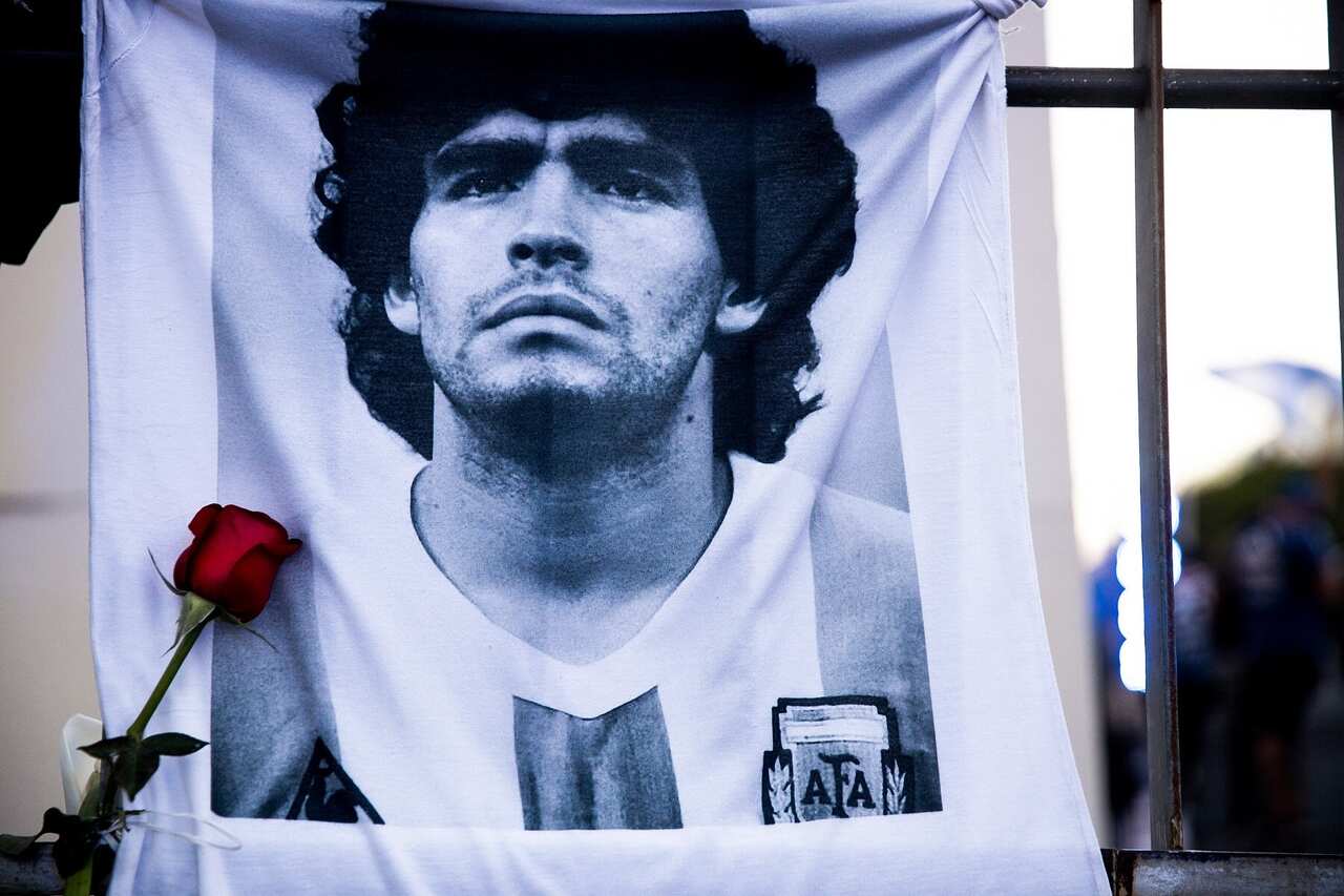 A shirt with an image of Diego Maradona on a fence in Buenos Aires, Argentina 