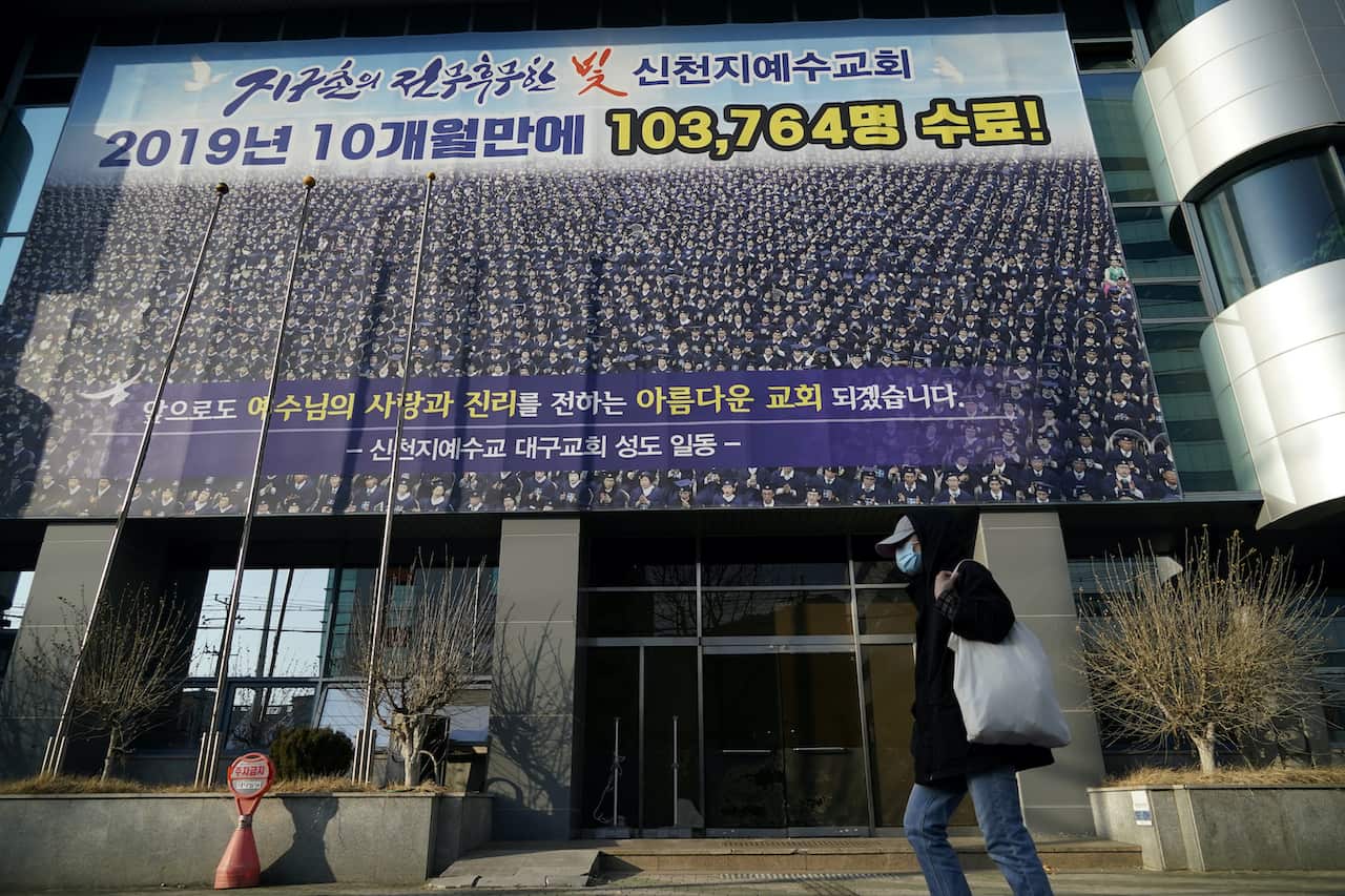 A man wearing a mask to prevent contracting the coronavirus walks past a branch of the Shincheonji Church of Jesus the Temple of the Tabernacle of the Testimony in Daegu