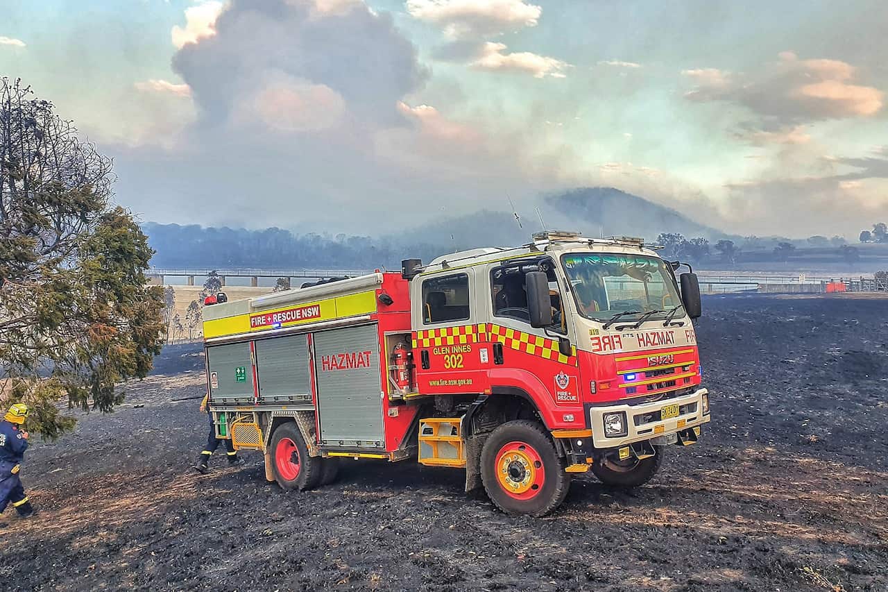 Firefighters from Fire and Rescue NSW, Station 302 Glen Innes assist in the fight against a bushfire in Tenterfield.