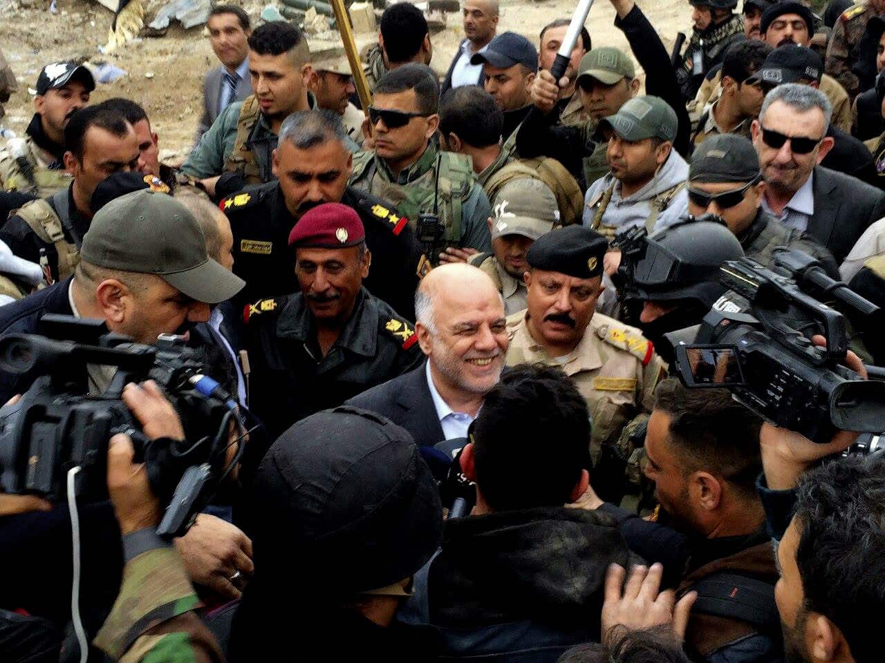 Iraqi Prime Minister Haider al-Abadi, center, smiles as he tours the city of Ramadi after it was retaken by the security forces in Ramadi