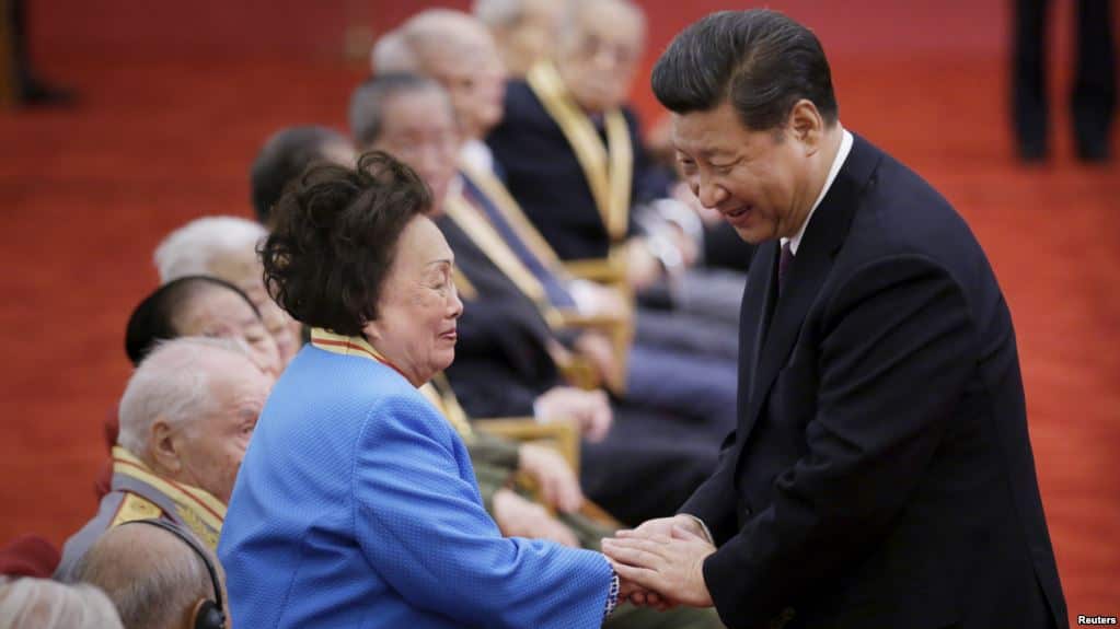 中国国家主席习近平在纪念中国抗日战争胜利60周年的一次颁奖仪式上与飞虎队将军陈纳德的遗孀陈香梅握手。