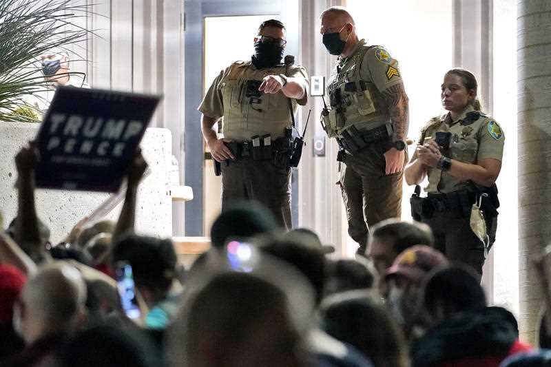 Maricopa County Sheriff's Deputies stand at the door of the Maricopa County Recorder's Office as President Donald Trump supporters rally outside,