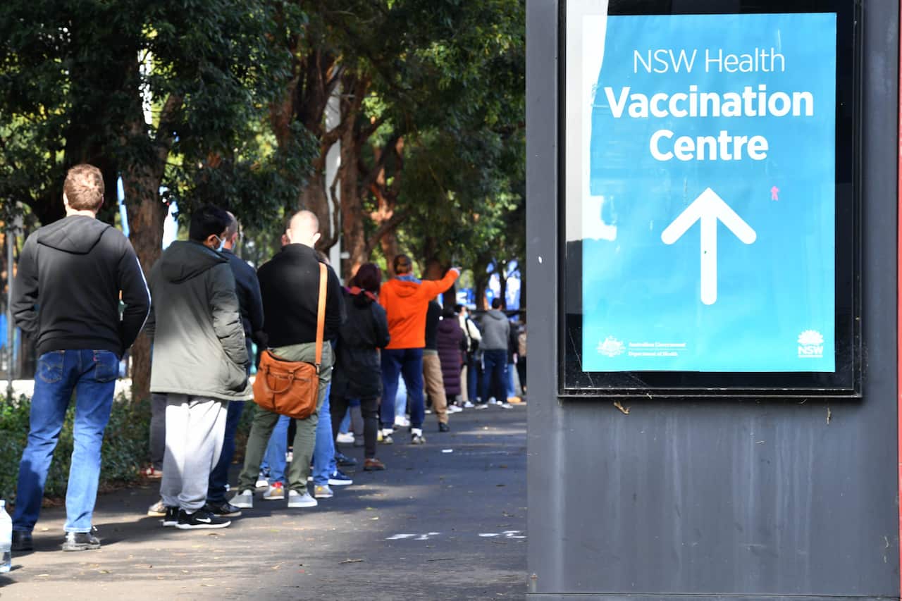 People are seen queued to receive their vaccination at the NSW Vaccine Centre at Homebush Olympic Park in Sydney.