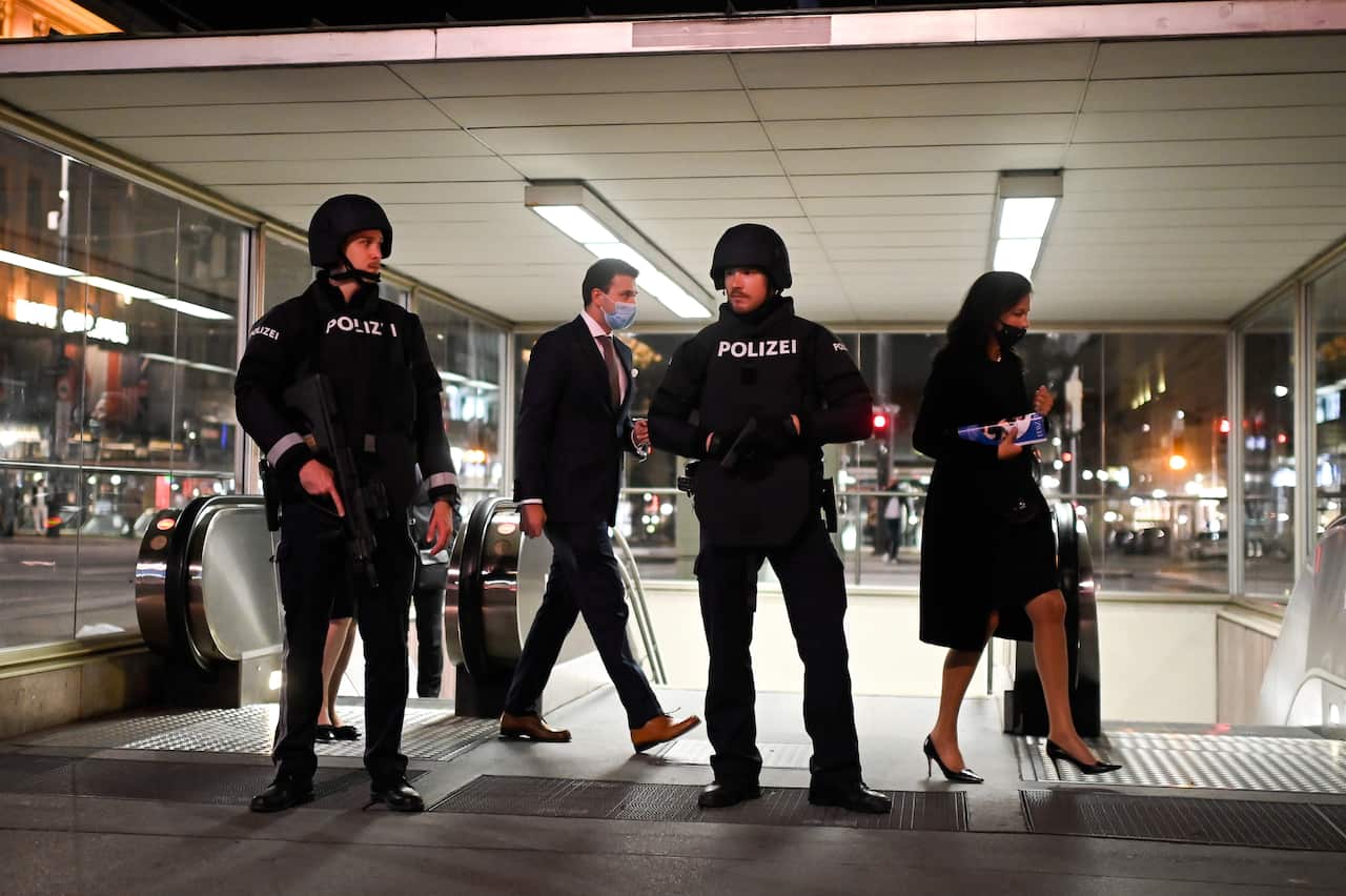 Austrian police guard visitors at Vienna State Opera as they leave a subway station after the attack. 