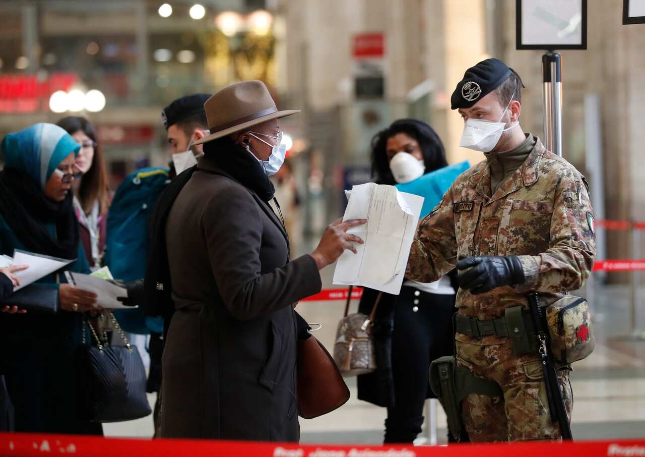 Police officers and soldiers check passengers leaving from Milan main train station, Italy, Monday, 9 March, 2020. 