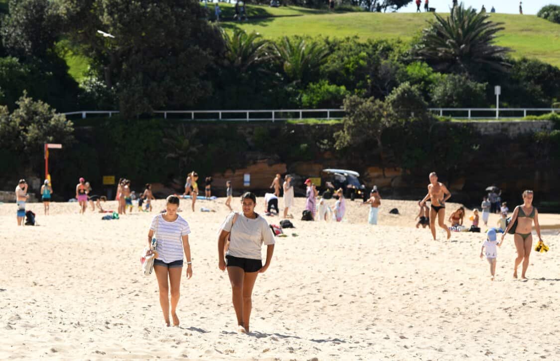 Beachgoers swimming and exercising on the sand at Coogee Beach in Sydney, Wednesday, April 22, 2020