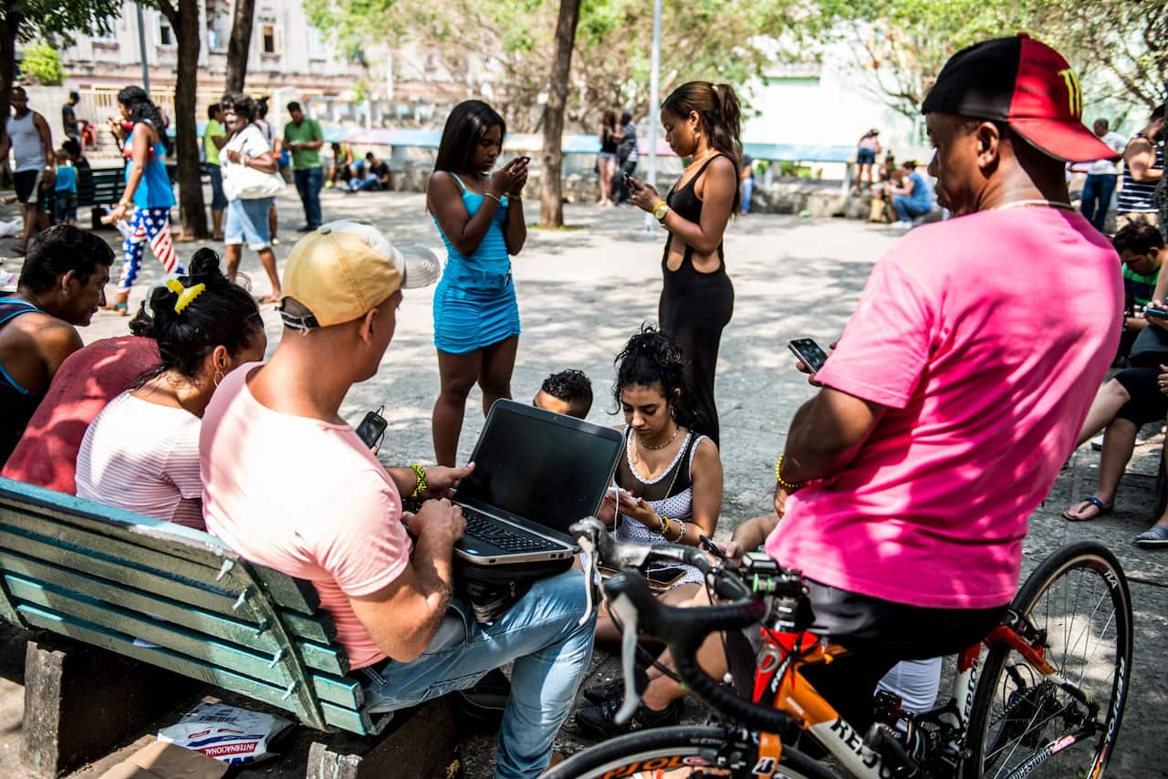 A group of young Cubans enjoy WiFi internet