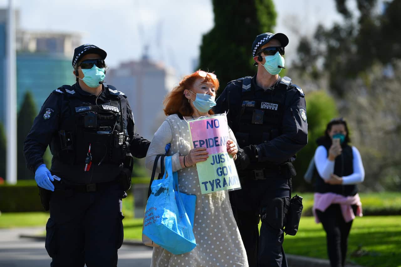 A protester is arrested by Victoria Police officers outside of the Shrine of Remembrance.