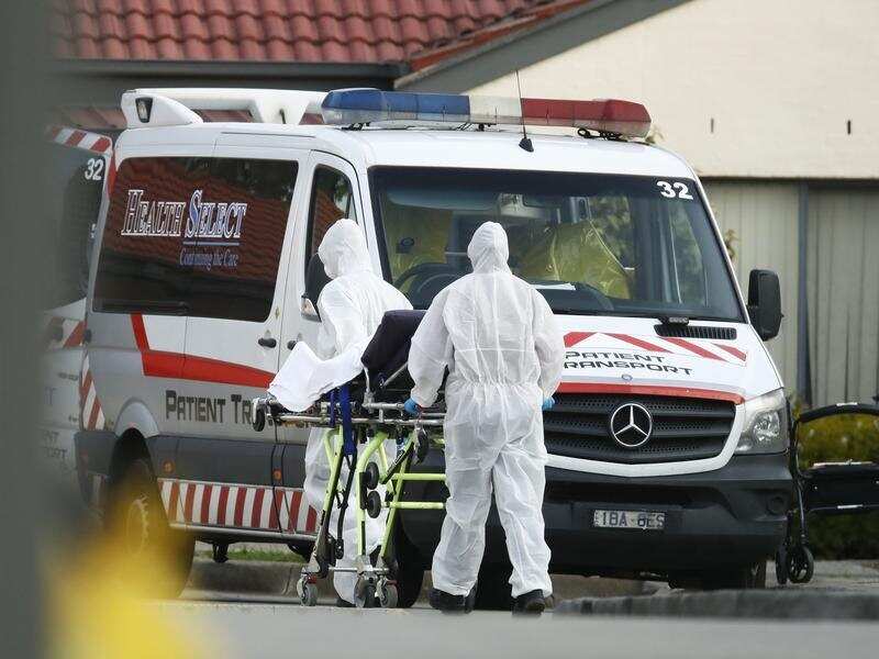 Health workers remove resident from St. Basil's aged care in Fawkner.