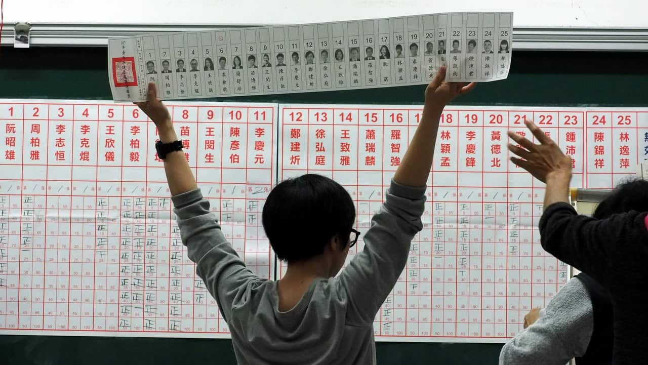 An election worker displays a ballot during vote count at a polling station in Taipei.
