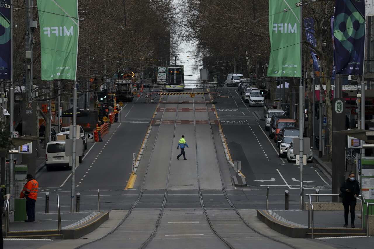 A worker is seen crossing a quiet Bourke Street in Melbourne.