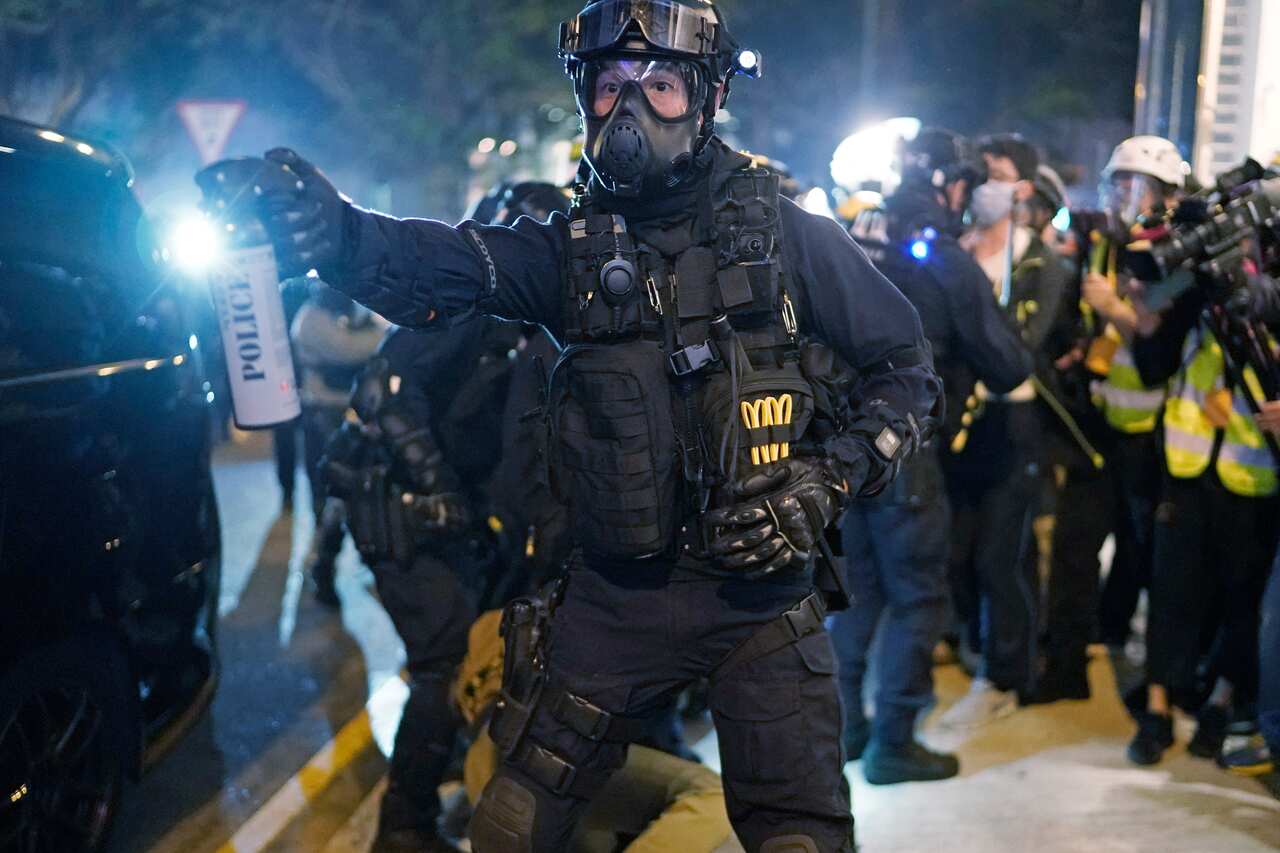 A riot police gestures, to a crowd to clear the area during a rally on Christmas Eve in Hong Kong.