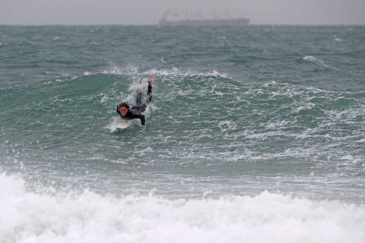 Surfers are seen at Port Beach in Fremantle.