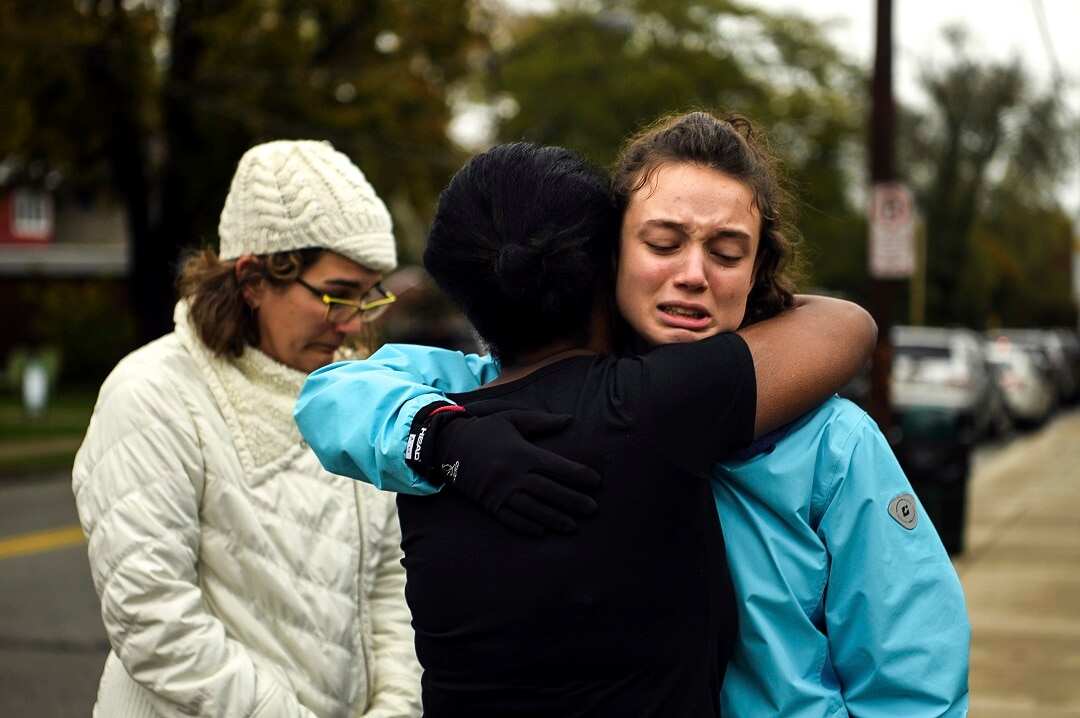 Friends and family hug after a deadly shooting at a Pittsburgh synagogue.