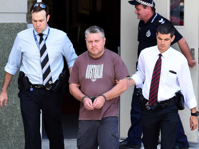 Rick Thorburn is escorted by police from a police station
