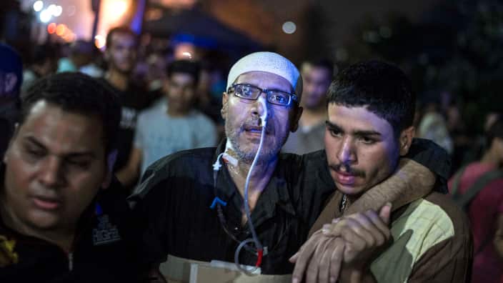 eople transport an injured from a blast inside the National Cancer Institute, Cairo, Egypt