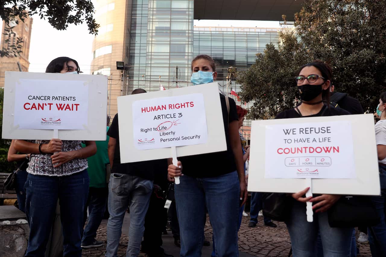 Cancer patients hold placards during a sit-in to protest shortages in medications amid Lebanon's severe economic crisis in front of the U.N. headquarters in Beirut, Lebanon, Thursday, Aug. 26, 2021. (AP Photo/Bilal Hussein)