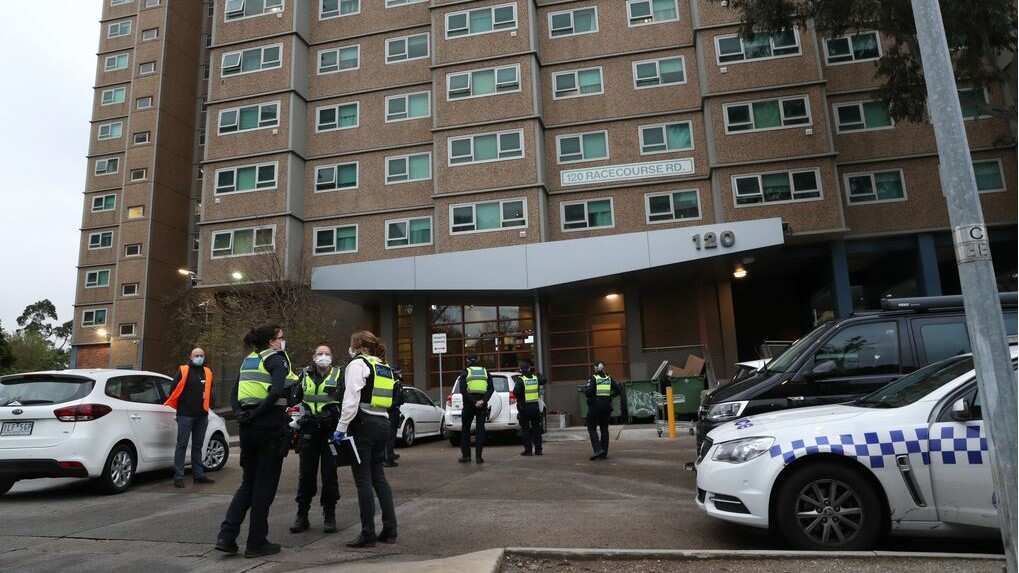 Police are seen enforcing a lockdown at public housing towers on Racecourse Road in Flemington, Melbourne.