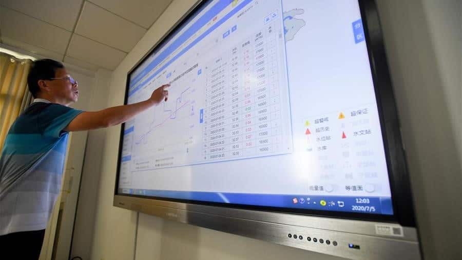 A staff member of local hydrological bureau checks water level statistics of Dongting Lake, water level of which surpasses the warning level, in Yueyang City, central China's Hunan Province, July 5, 2020.