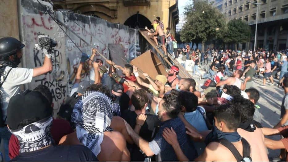Lebanese anti-government protesters pull a protection wall leading to the Parliament square during a protest in Beirut. 