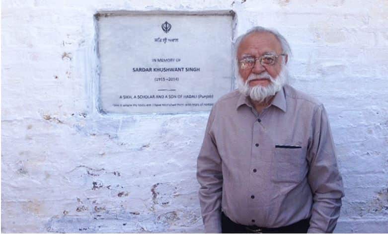 Rahul Singh in front of the plaque fixed on the school in the village Hadali where their father Khushwant Singh studied about 90 years ago.