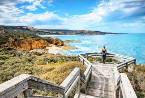 A woman on a viewpoint looking down the beach at Bells Beach near Torquay, Victoria.