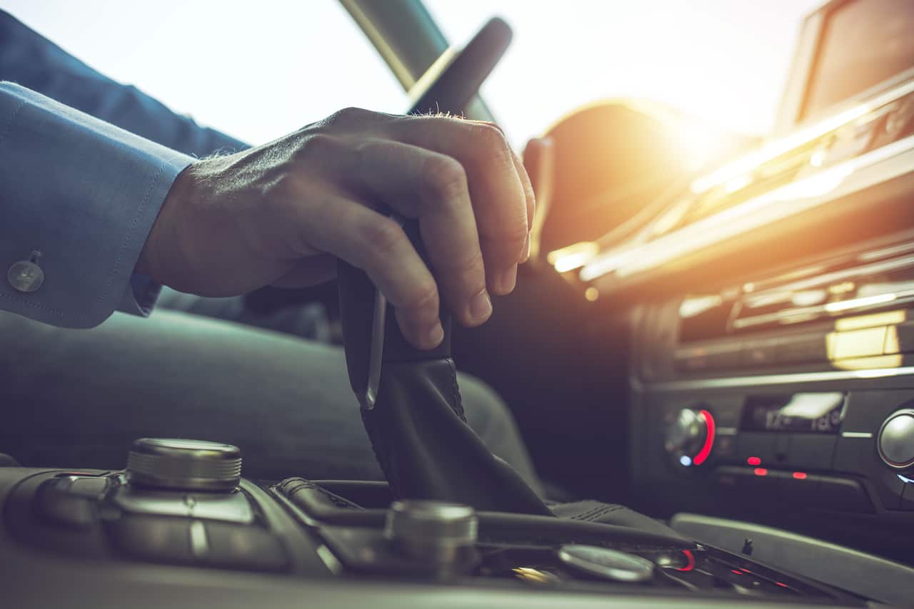 Car Driving Concept. Driver Shifting To Drive Mode. Hand on Transmission Stick Closeup