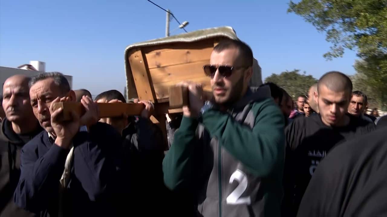Men carry the casket through the town. 