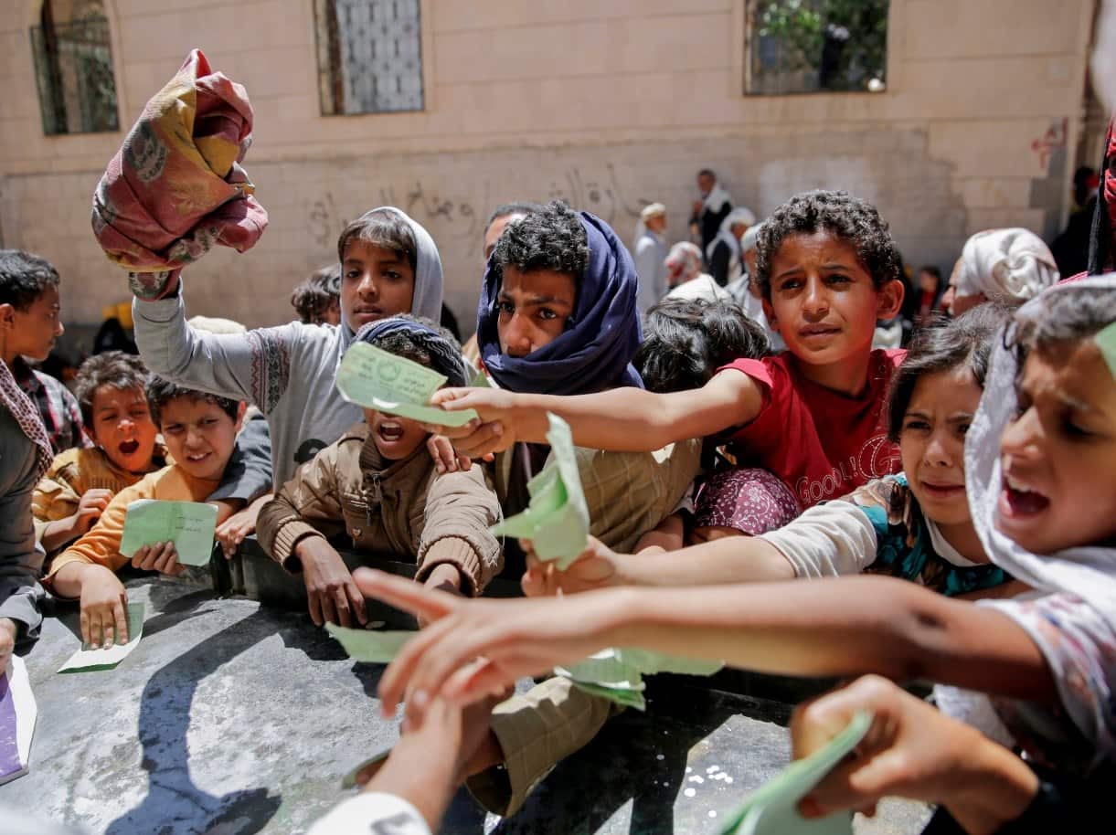 Yemenis present documents in order to receive food rations provided by a local charity, in Sanaa, Yemen, Thursday, April, 13, 2017.