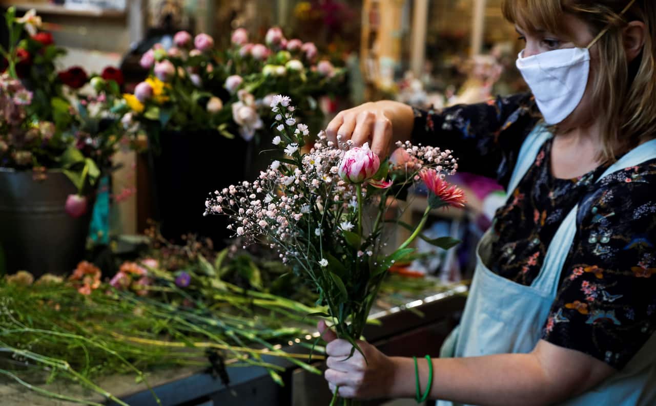 A florist wearing a face mask prepares a flower bouquet in Hondarribia, northern Spain.