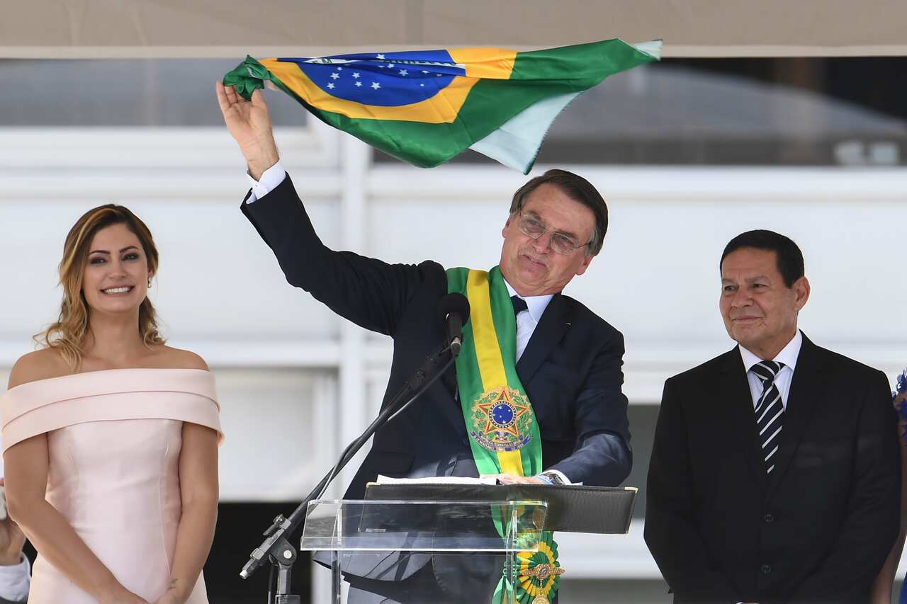 President Jair Bolsonaro addressing supporters flanked by First Lady Michelle Bolsonaro and Vice-President Hamilton Mourao.