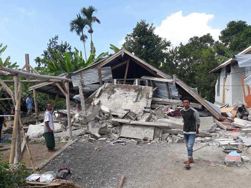 Villagers walk near destroyed homes.