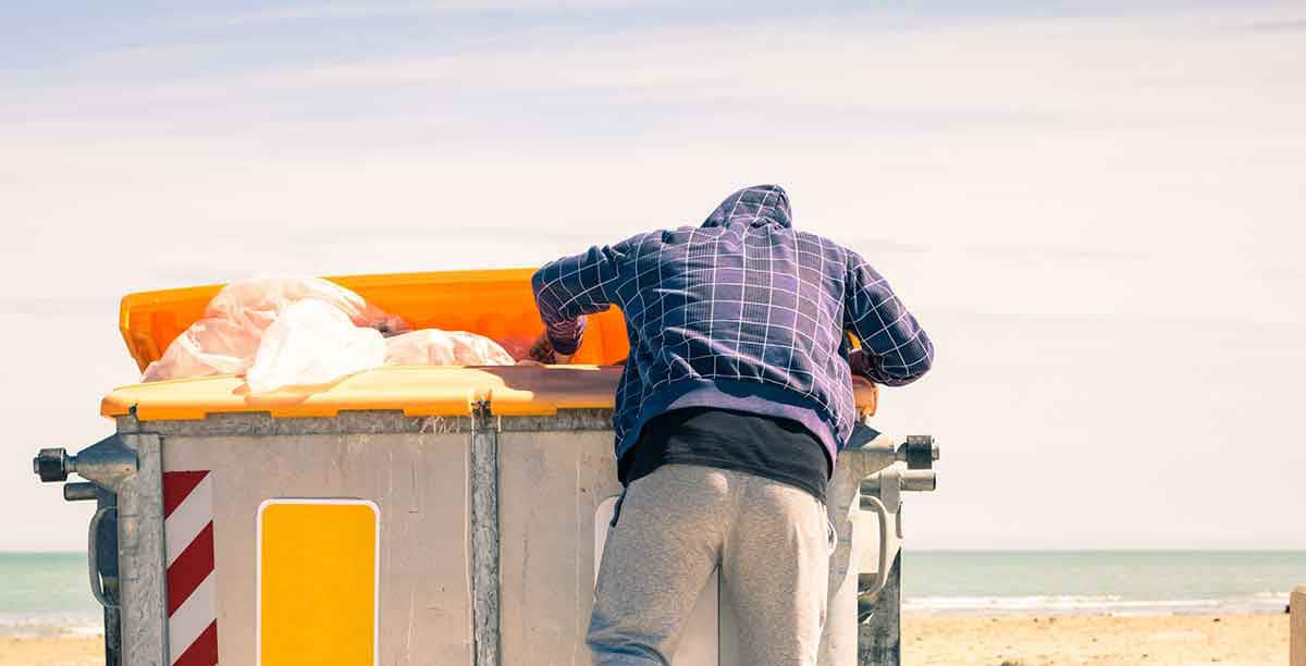 Man digs through rubbish dumpster