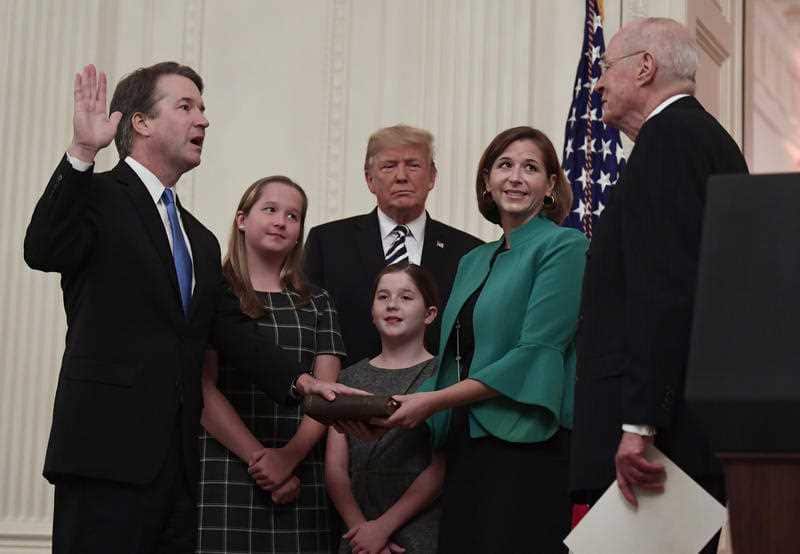 President Donald Trump listens as retired Supreme Court Justice Anthony Kennedy swears-in Supreme Court Justice Brett Kavanaugh.