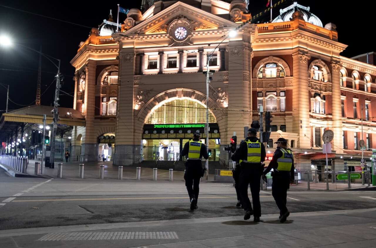 Police are seen in front of Flinders Street Station during a 8PM-5AM curfew in Melbourne, Saturday, August 8, 2020.