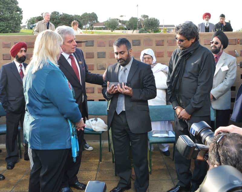 Kapil Dev stands alongside Harmel Uppal as they receive Pooran Singh's ashes from the Guyett family of Warrnambool, Victoria