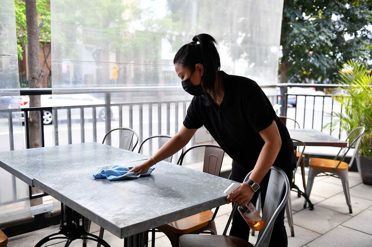 Workers clean tables for outdoor dining at Sambandha Nepalese restaurant at Auburn in Sydney
